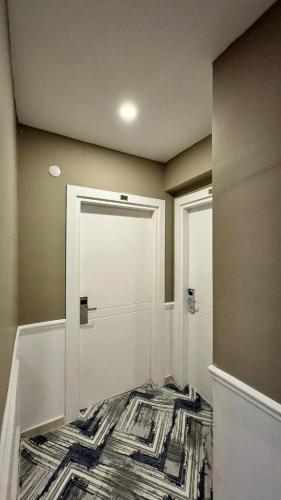 a hallway with a white door and a rug at Bahçeli Butik Otel 
