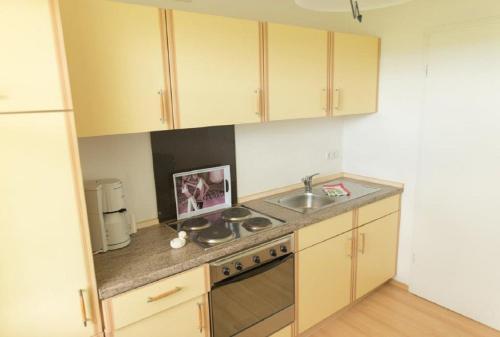 a kitchen with a sink and a stove top oven at ausZEIT - Ihr Sibyllenbad Gästehaus in Neualbenreuth