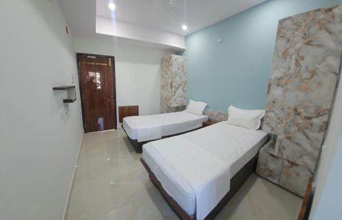 a bedroom with two beds and a stone wall at aspire living in Hyderabad