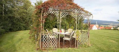 a gazebo with a table and chairs in a field at ausZEIT - Ihr Sibyllenbad Gästehaus in Neualbenreuth