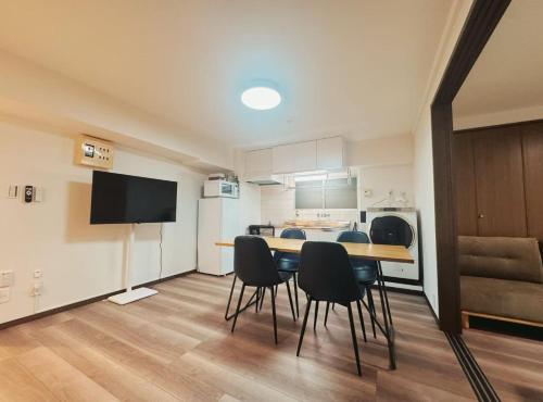 a room with a table and chairs and a kitchen at LoveTokyo Easy Access Nezu Sunset House 根津駅徒歩1分 エレベーター 上野 谷中銀座 根津神社 東京大学 新宿 渋谷 銀座 築地 原宿近い in Tokyo