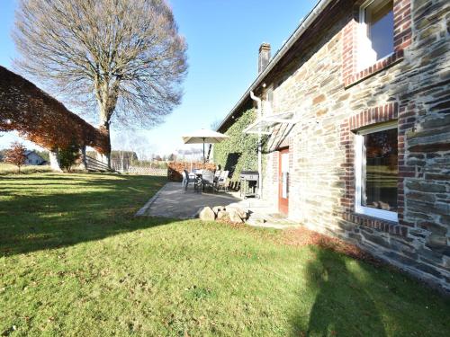 a dog laying on the grass next to a building at Cottage in Kuchelscheid with Terrace in Küchelscheid