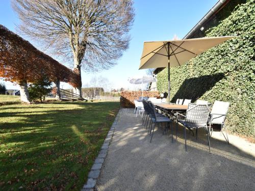 a table and chairs with an umbrella in a yard at Cottage in Kuchelscheid with Terrace in Küchelscheid