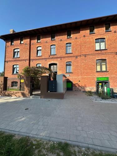a large red brick building with a large doorway at Apartament mieszkanie blisko centrum nowe zadbane in Słupsk
