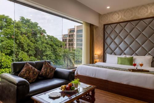 a hotel room with a bed and a large window at Aliste Millennium Huda City Centre in Gurgaon