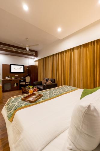 a hotel room with a bed and a tv at Aliste Millennium Huda City Centre in Gurgaon