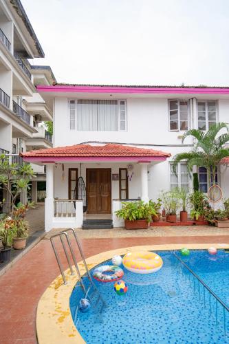 a swimming pool in front of a house at Lostparadise 3bedroom villa in Vagator