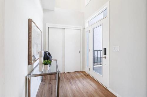 a hallway with white walls and a glass table and a window at Magnificent Stylish Escape in Bélanger