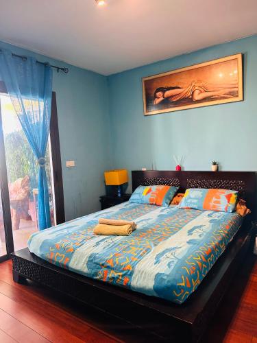 a bedroom with a large bed with blue walls at Villa F5 vue sur mer 