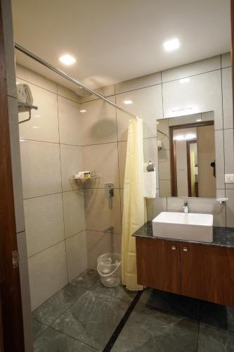 a bathroom with a sink and a mirror at Hotel Abaam Neil in Kumarakom