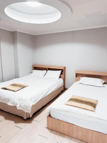 two beds in a room with a ceiling at Daegu Dongseongro Gyeong`s Hostel in Daegu