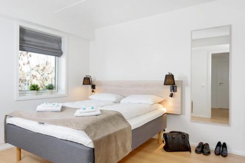 a bedroom with a large bed and a mirror at The Apartments Company - Majorstuen in Oslo
