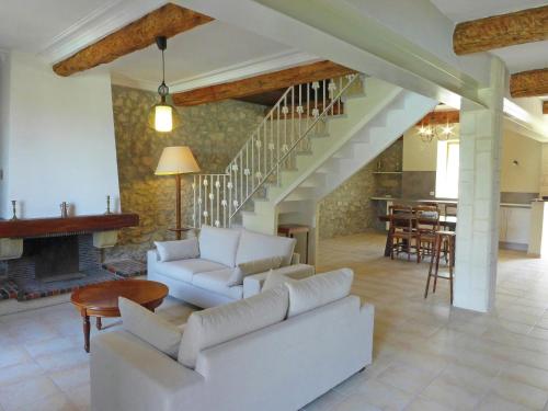 a living room with white furniture and a staircase at Holiday Home in Montbrun with Pool & Vineyards in Montbrun-des-Corbières
