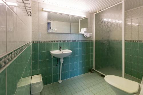 a bathroom with a sink and a shower and a toilet at Hotel Esplanad in Mariehamn