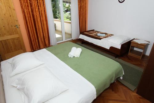 a hotel room with two beds and a window at Apartments Majica in Sveti Filip i Jakov