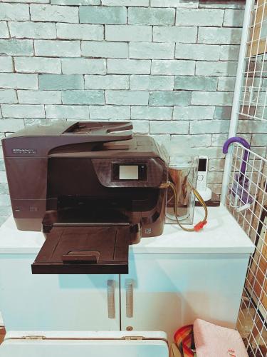 a printer sitting on a counter next to a brick wall at Daegu Dongseongro Gyeong`s Hostel in Daegu