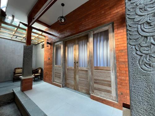 a building with wooden doors on a brick wall at The Banjar Homestay in Sidemen