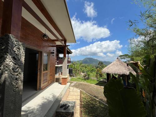 a view of a house with a view of the mountains at The Banjar Homestay in Sidemen