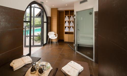 bagno con doccia, tavolo e specchio di Hotel Restaurant De l'Illwald a Sélestat