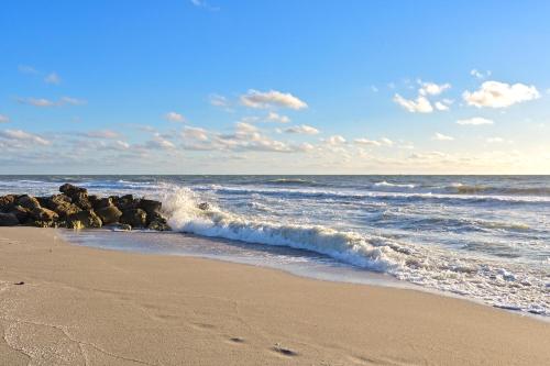 a sandy beach with waves crashing on the shore at Naples Getaway in Naples