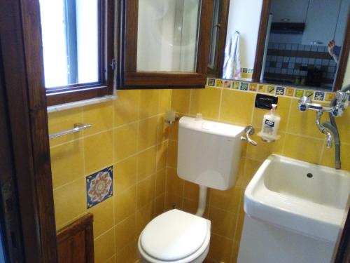 ein Badezimmer mit weißer Toilette und Waschbecken in der Unterkunft Arte Mare e Cultura in Pettineo
