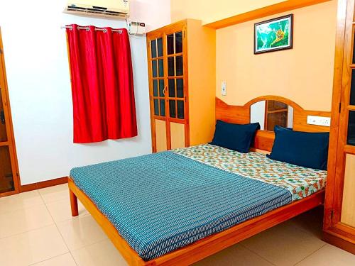 a bedroom with a bed with a red curtain at Helios Villa in Auroville