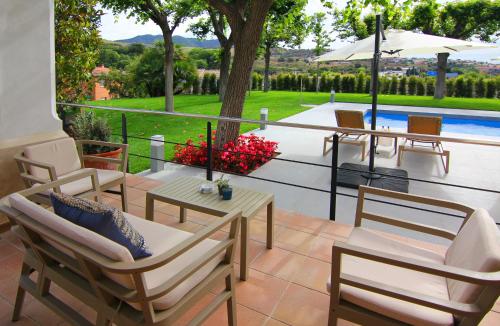 a patio with chairs and a table and an umbrella at Hotel Arrey Alella in Alella