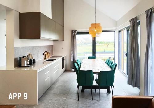 Una cocina y un comedor con mesa y sillas. en Tussen Dijken, en Hollum
