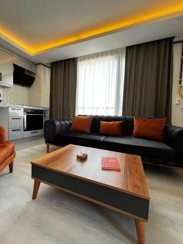 Sala de estar con sofá negro y mesa de centro en Lighthouse Suite, en Atakum