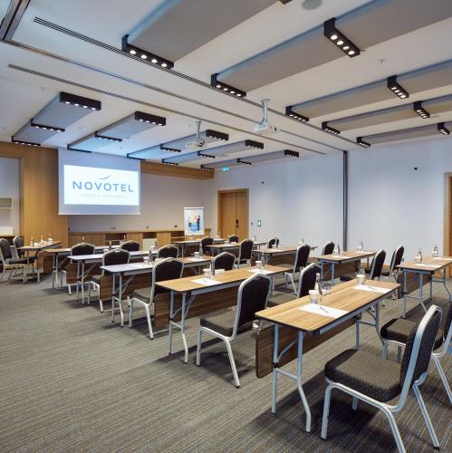 a classroom with tables and chairs and a projection screen at Novotel Konya in Konya