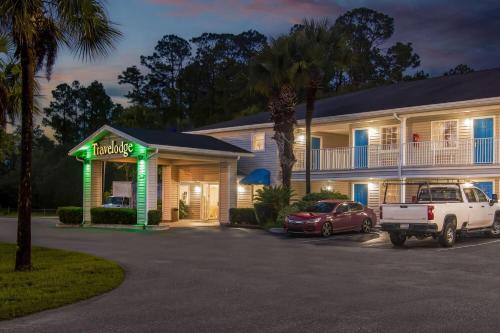 a hotel with cars parked in a parking lot at Travelodge Suites by Wyndham MacClenny I-10 in Macclenny