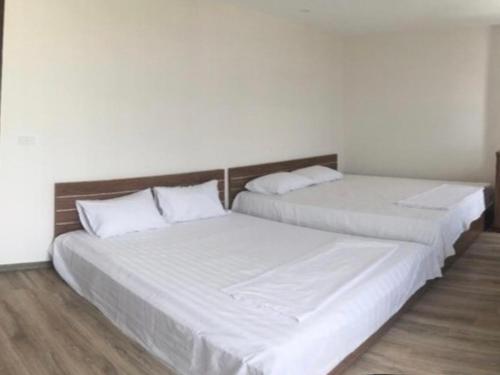 two beds in a room with white sheets and pillows at Lucky 12 in Bắc Ninh
