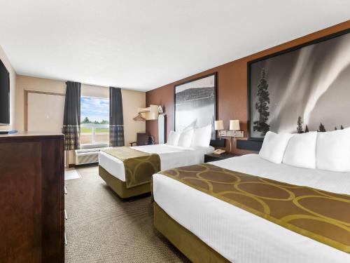 a hotel room with two beds and a television at Super 8 by Wyndham Meadow Lake in Meadow Lake