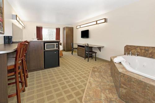 a hotel room with a tub and a kitchen at Microtel Inn & Suites Cheyenne in Cheyenne