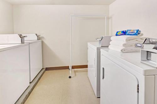 a white kitchen with white cabinets and white appliances at Microtel Inn & Suites Cheyenne in Cheyenne