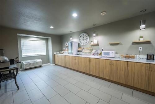 a restaurant with a counter and a clock on the wall at Microtel Inn & Suites Cheyenne in Cheyenne