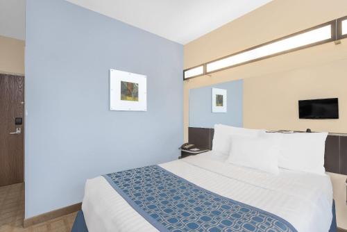 a hotel room with a bed and a tv at Microtel Inn & Suites by Wyndham Waynesburg in Waynesburg