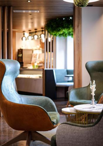 a room with three chairs and a table and a counter at Best Western Plus Parkhotel Erding in Erding