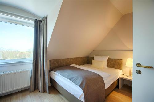 a small bedroom with a bed and a window at Best Western Plus Theodor Storm Hotel in Husum