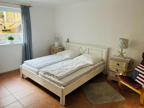 a bedroom with a bed and a chair and a window at Neptun in Scharbeutz