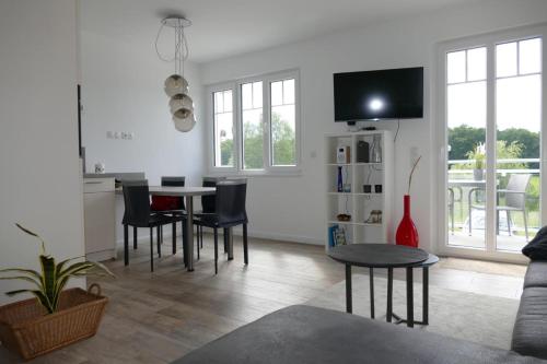 a living room with a table and chairs and a tv at Come In Haffkrug in Haffkrug