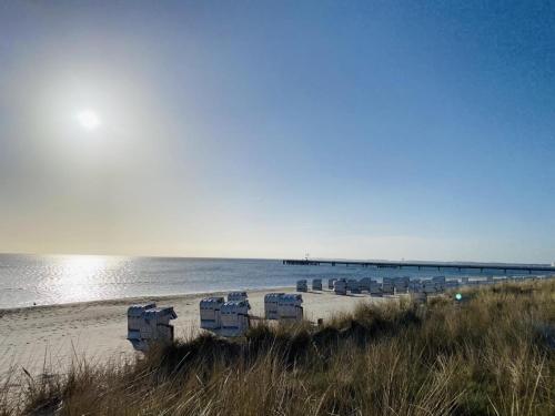 una playa con sillas y un muelle en el agua en Haus Larum App. 3, en Scharbeutz