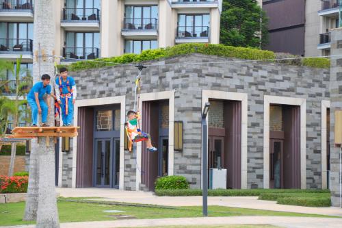 a statue of three men on a sign in front of a building at Hilton Wenchang in Wenchang