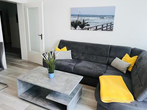 a living room with a black couch and a table at Zur Seeschwalbe in Scharbeutz