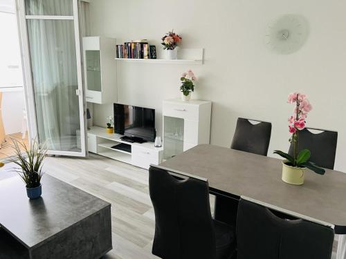 a living room with a table and chairs and a television at Zur Seeschwalbe in Scharbeutz