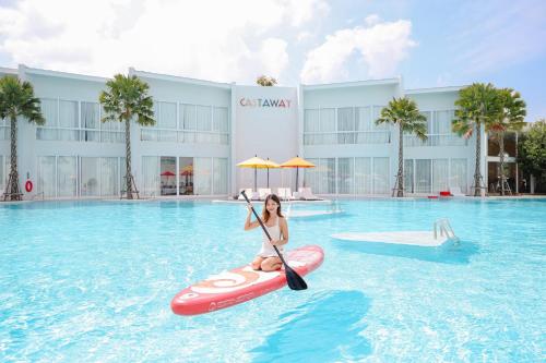 a woman riding on a paddle board in a pool at The Gems Mining Pool Villas Pattaya in Nong Prue