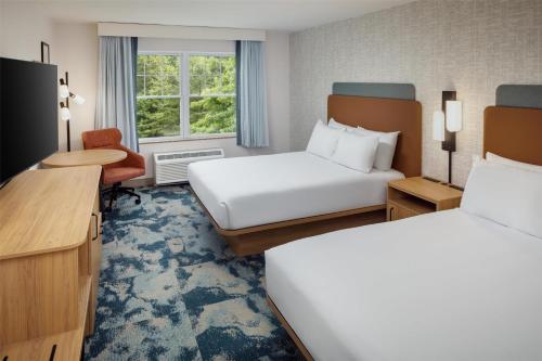 a hotel room with two beds and a desk at Hampton Inn & Suites North Conway in North Conway