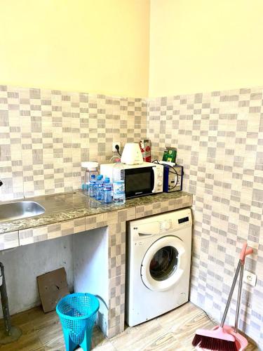 a kitchen with a washing machine under a counter at Home RÉSIDENCE OUIDAH in Ouidah
