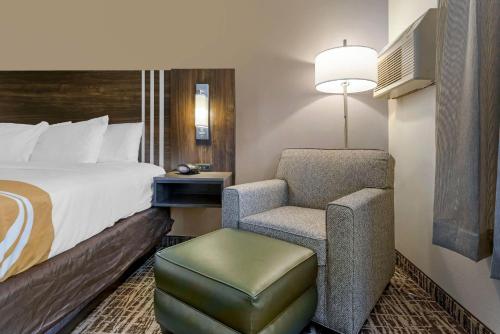 a hotel room with a bed and a chair at Quality Inn St Cloud West in Saint Cloud