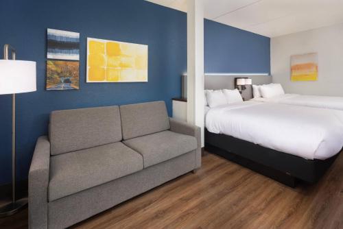 a hotel room with a bed and a couch at Comfort Suites Outlet Center in Asheville